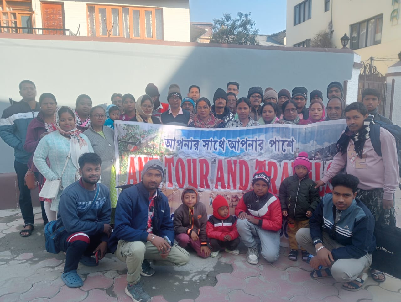 Travel group holding an Anu Tour and Travels banner